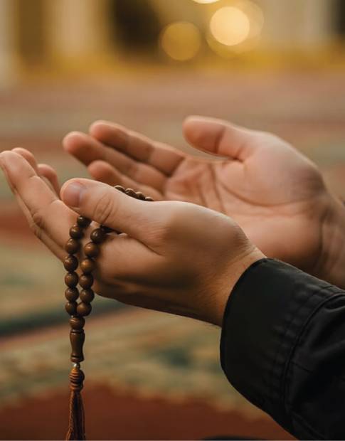 Hands holding prayer beads in dua